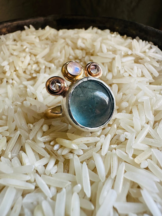Flourite and Moonstone Statement Ring with Cubic Zirconia Accents, Handcrafted in 14k Gold Fill and Sterling Silver. Ring sitting in a bed of rice in a tarnished, vintage Silver Cup