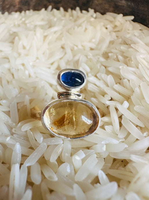 Oval Citrine Cabochon Ring with Blue Sapphire and Silver Accents. Organic hammered statement ring set with 14k Gold Fill Band. Ring displayed in a vintage silver bowl of white rice. 