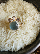 Load image into Gallery viewer, Flourite and Moonstone Statement Ring with Cubic Zirconia Accents, Handcrafted in 14k Gold Fill and Sterling Silver. Ring sitting in a bed of rice in a tarnished, vintage Silver Cup
