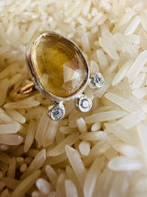 Load image into Gallery viewer, Rose Cut Citrine Ring with a Trio of Cubic Zirconia set in Silver accent Bubbles, Ring Sitting in a bed of white rice. 
