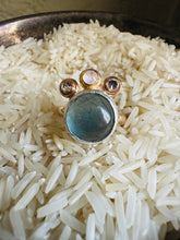 Load image into Gallery viewer, Flourite and Moonstone Statement Ring with Cubic Zirconia Accents, Handcrafted in 14k Gold Fill and Sterling Silver. Ring sitting in a bed of rice in a tarnished, vintage Silver Cup
