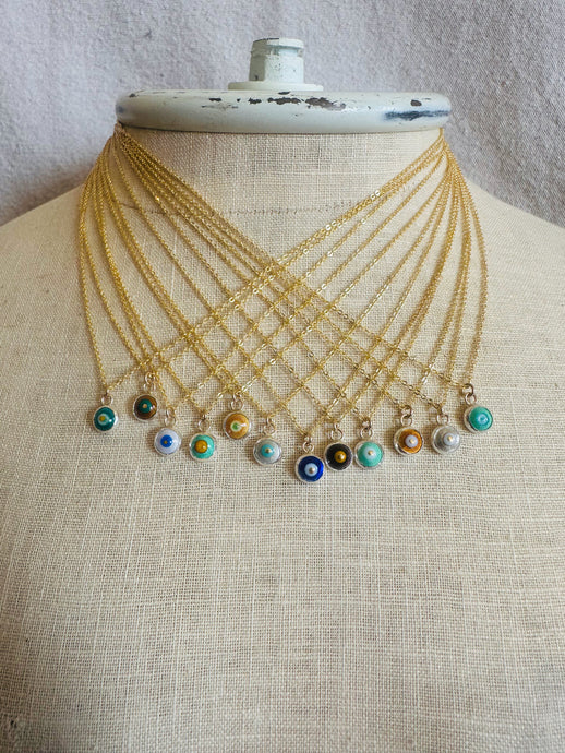 Twelve necklaces with colorful evil eye-pendants on a mannequin.