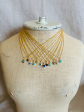 Load image into Gallery viewer, Gold necklace with evil eye charms on a mannequin bust against a neutral background
