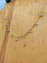 Load image into Gallery viewer, 14k Gold Fill Misty Morning Necklace with tiny dangling Cubic Zirconia Droplets, draped on a wooden clipboard
