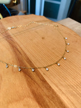 Load image into Gallery viewer, 14k Gold Fill Misty Morning Necklace with tiny dangling Cubic Zirconia Droplets laid round on a wooden table

