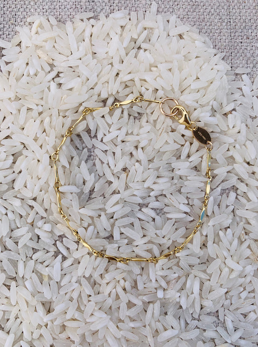14k Gold Fill Magic Hour Chain Bracelet displayed on a bed of white rice
