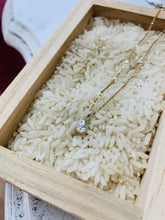 Load image into Gallery viewer, Textured fine silver Moonbeam pendant on 14k Gold Fill cable chain. Necklace is shown in a wooden tray full of white rice.
